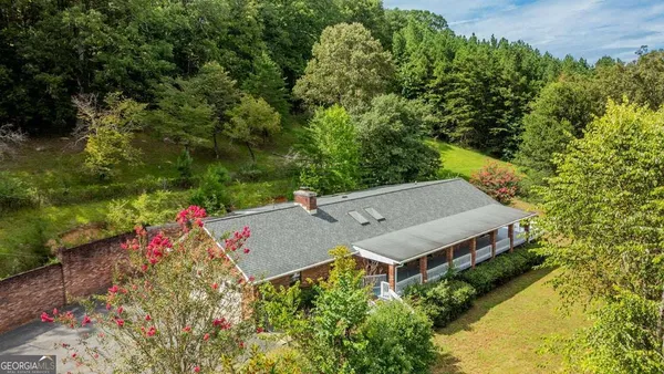an aerial view of a house with swimming pool and garden space