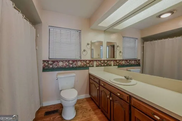 a bathroom with a granite countertop sink a toilet and a mirror