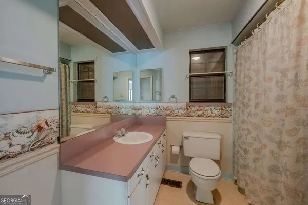 a bathroom with a sink toilet and mirror