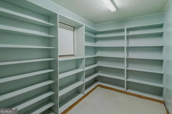 a view of walk in closet with empty racks