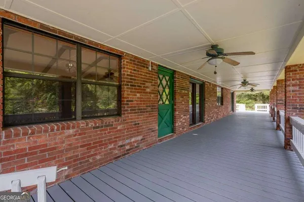a view of a porch with wooden floor and a floor to ceiling window