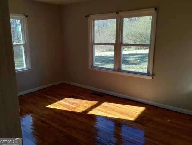 a view of a room with wooden floor and a window