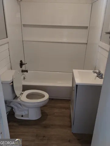 a white toilet sitting next to a bath tub