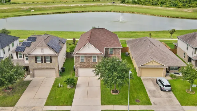 an aerial view of a house with a garden and lake view