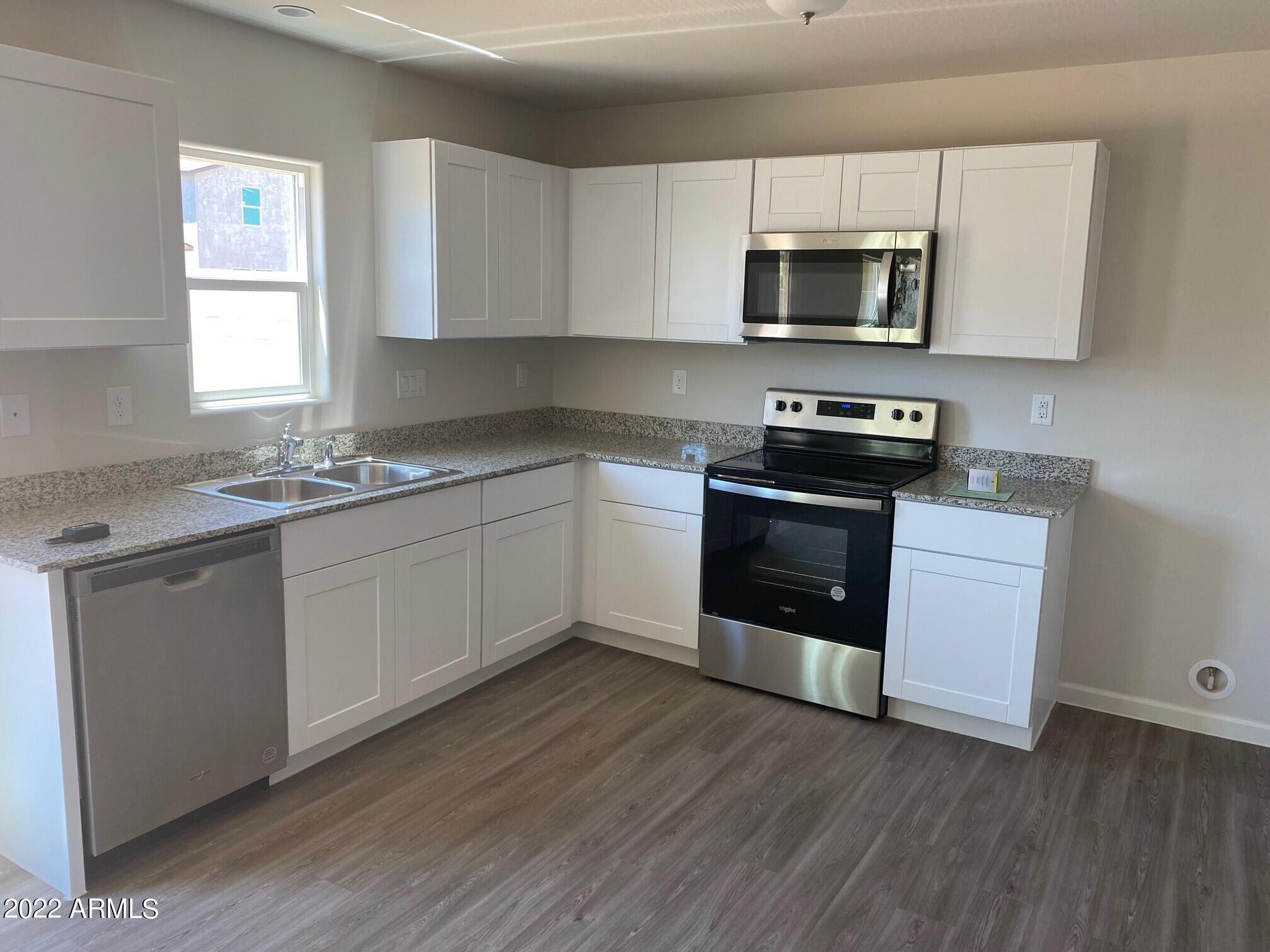 119 Dewey Avenue Coolidge, AZ 85128 - Photo 2 of 15 a kitchen with stainless steel appliances granite countertop a stove a sink and a microwave