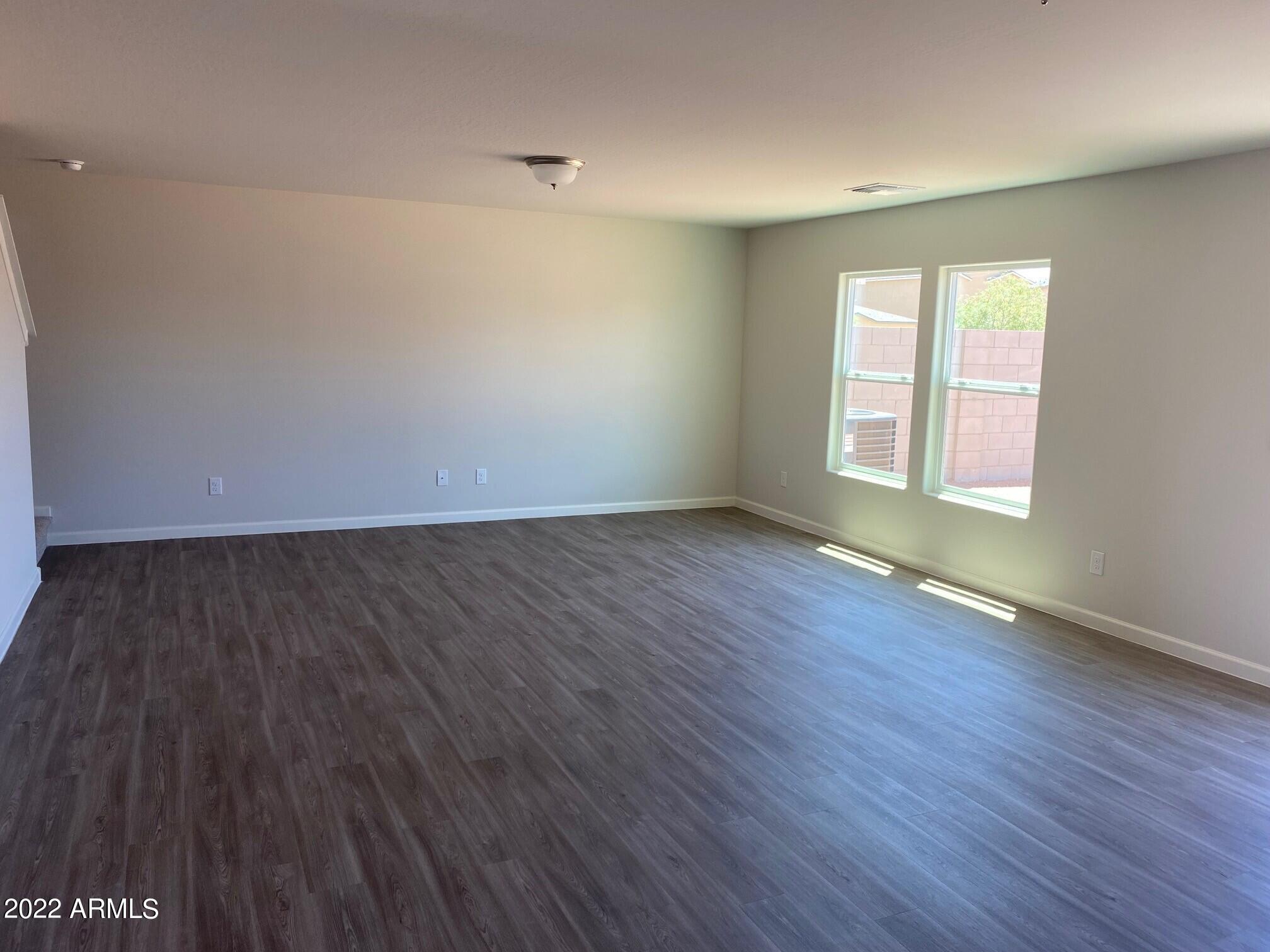 119 Dewey Avenue Coolidge, AZ 85128 - Photo 5 of 15 an empty room with wooden floor and windows
