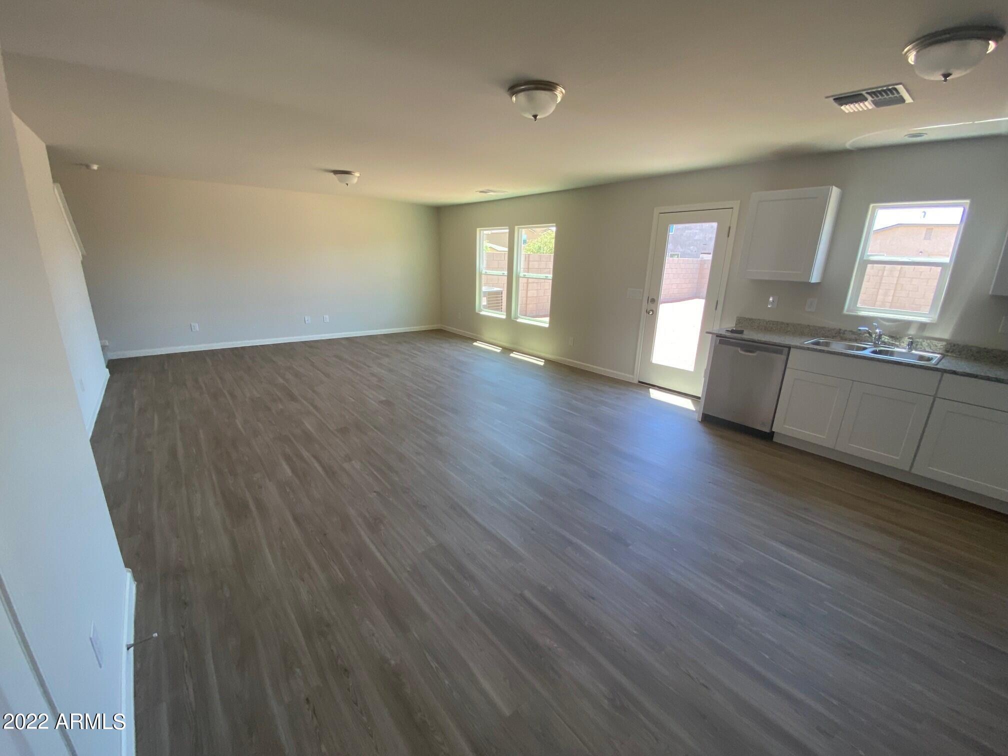 119 Dewey Avenue Coolidge, AZ 85128 - Photo 6 of 15 an empty room with wooden floor and windows