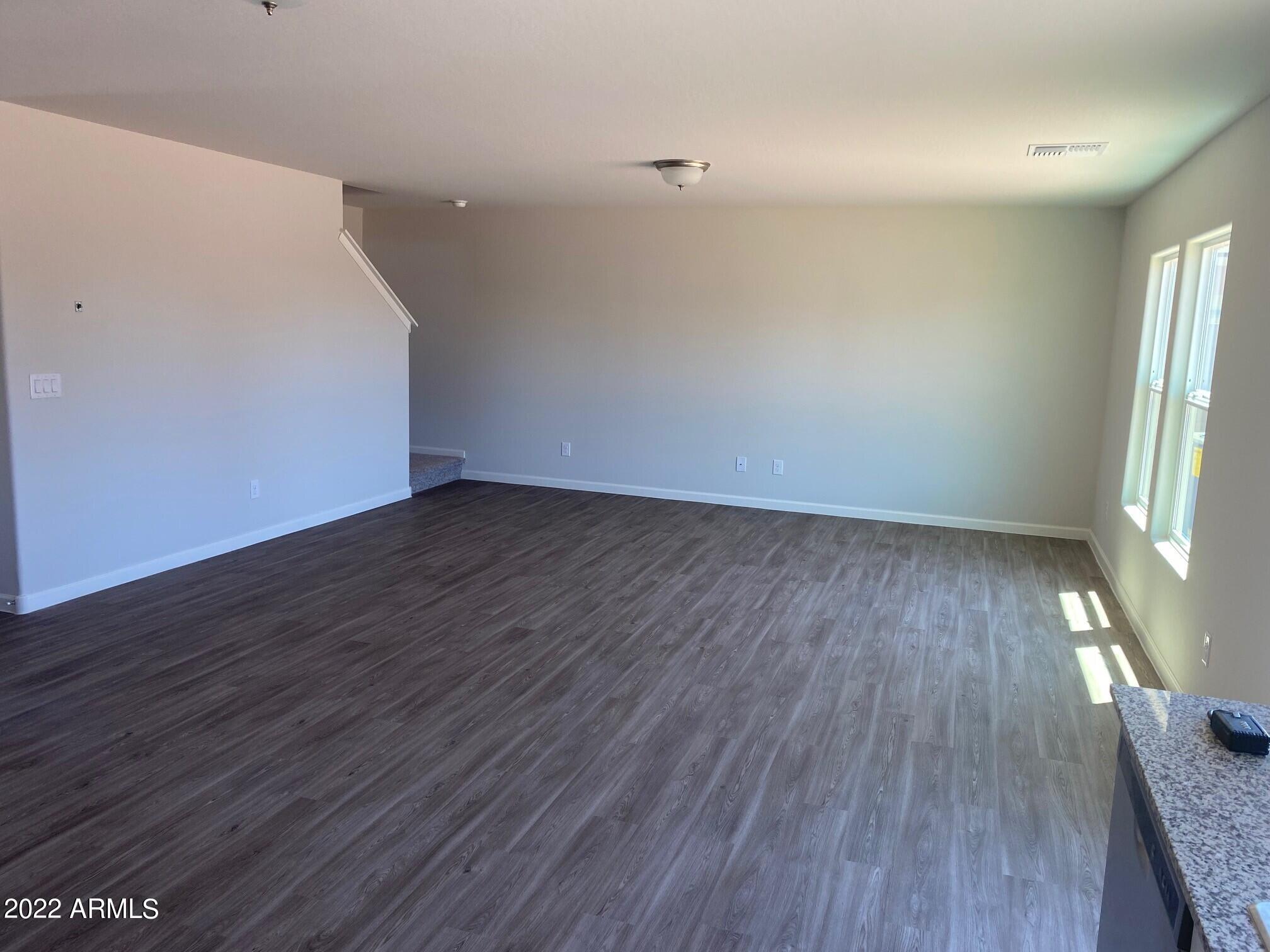 119 Dewey Avenue Coolidge, AZ 85128 - Photo 7 of 15 an empty room with wooden floor and windows
