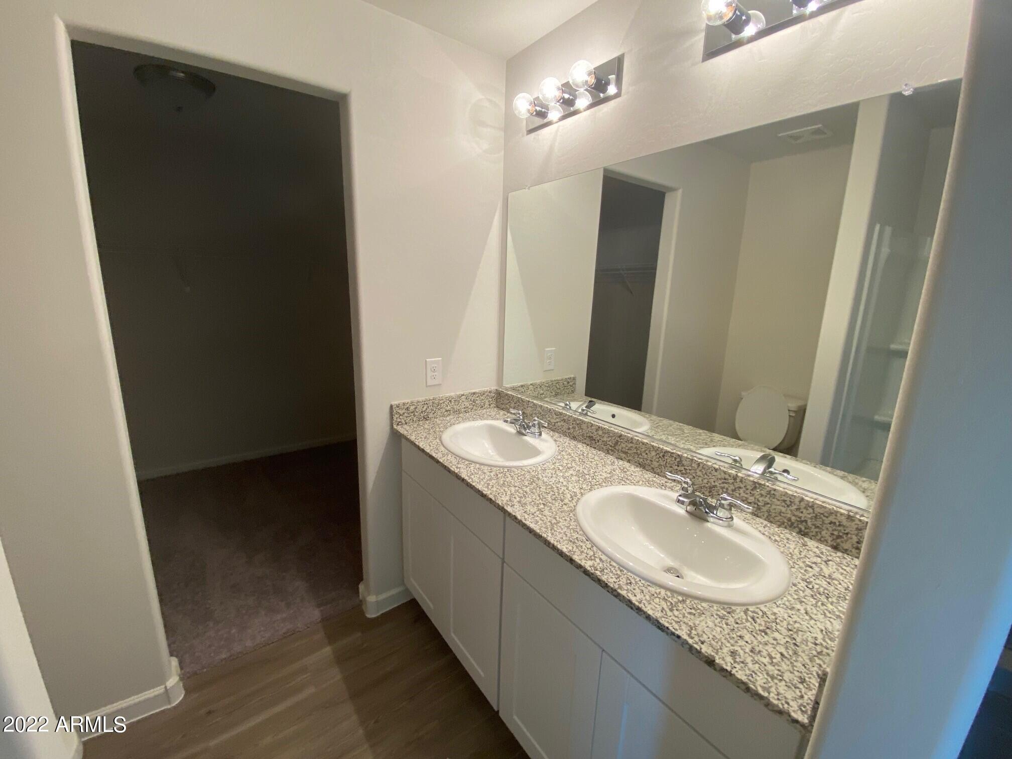 119 Dewey Avenue Coolidge, AZ 85128 - Photo 10 of 15 a bathroom with a granite countertop sink and a mirror