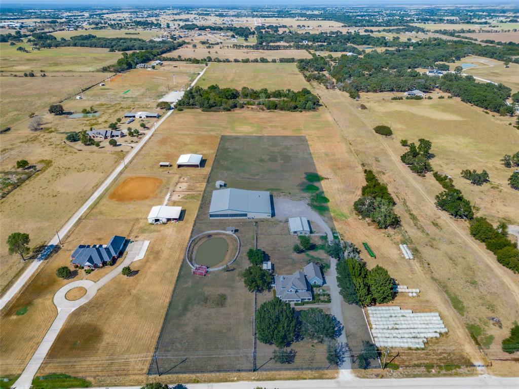 1601 East Blackjack Road East Pilot Point, TX 76258 - Photo 33 of 33 Expansive rural property featuring multiple structures, a circular driveway, a large pond, and a fenced arena