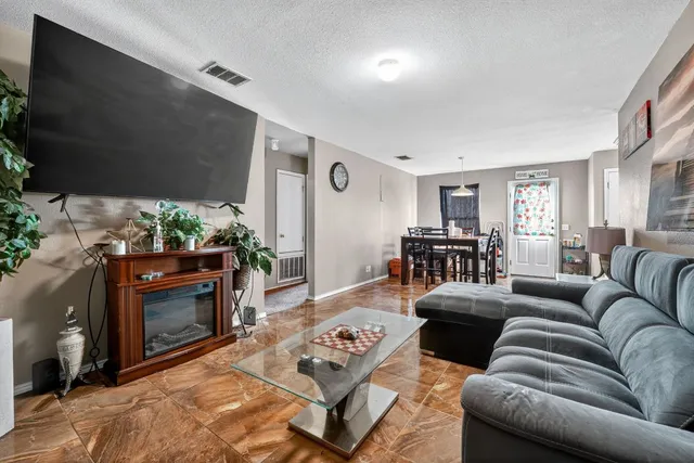 a living room with furniture a fireplace and a flat screen tv