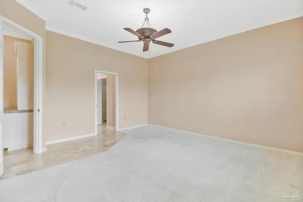 an empty room with a chandelier fan and closet area
