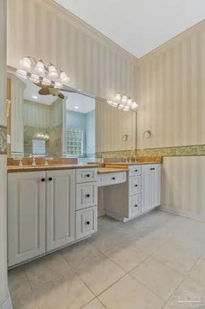 a bathroom with a granite countertop toilet sink and mirror