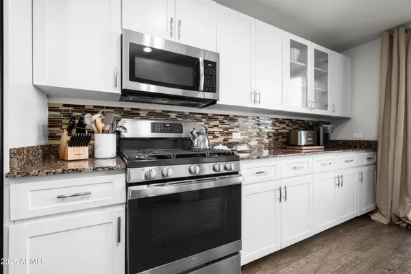 a bedroom with a bed a mirror and on the dresser