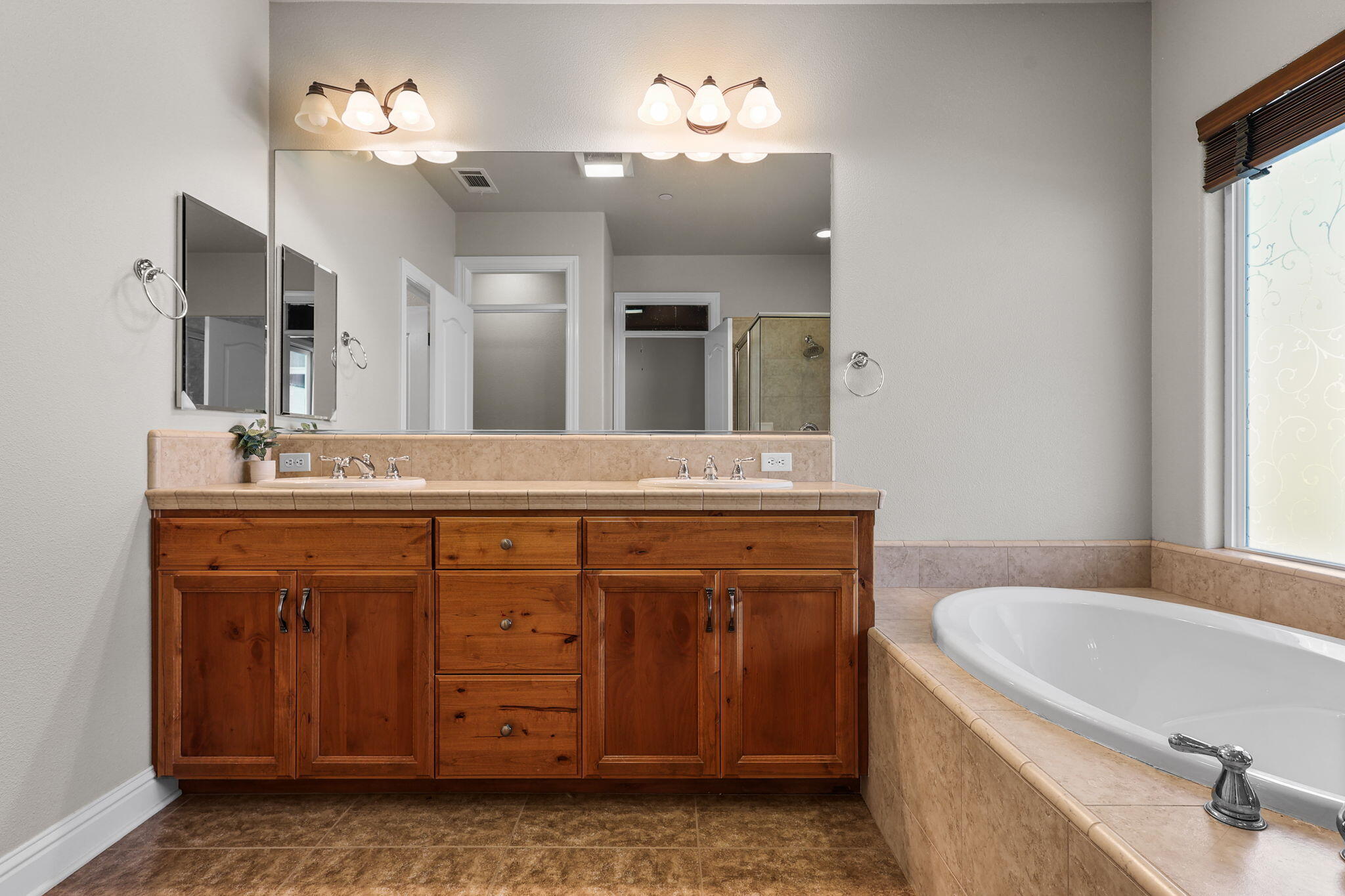 3641 Deuce Way Redding, CA 96002 - Photo 14 of 31 a bathroom with a granite countertop sink a large mirror a bathtub and shower