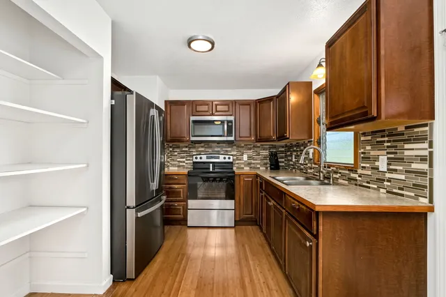 a kitchen with granite countertop stainless steel appliances and wooden cabinets