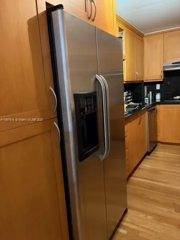 a view of a refrigerator with cabinets