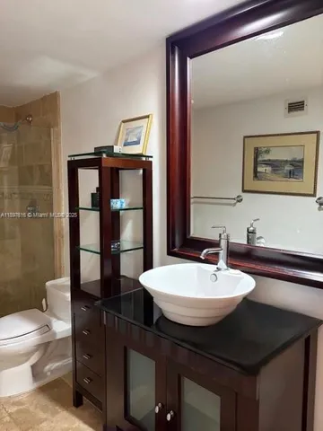 a bathroom with a sink a toilet and shower