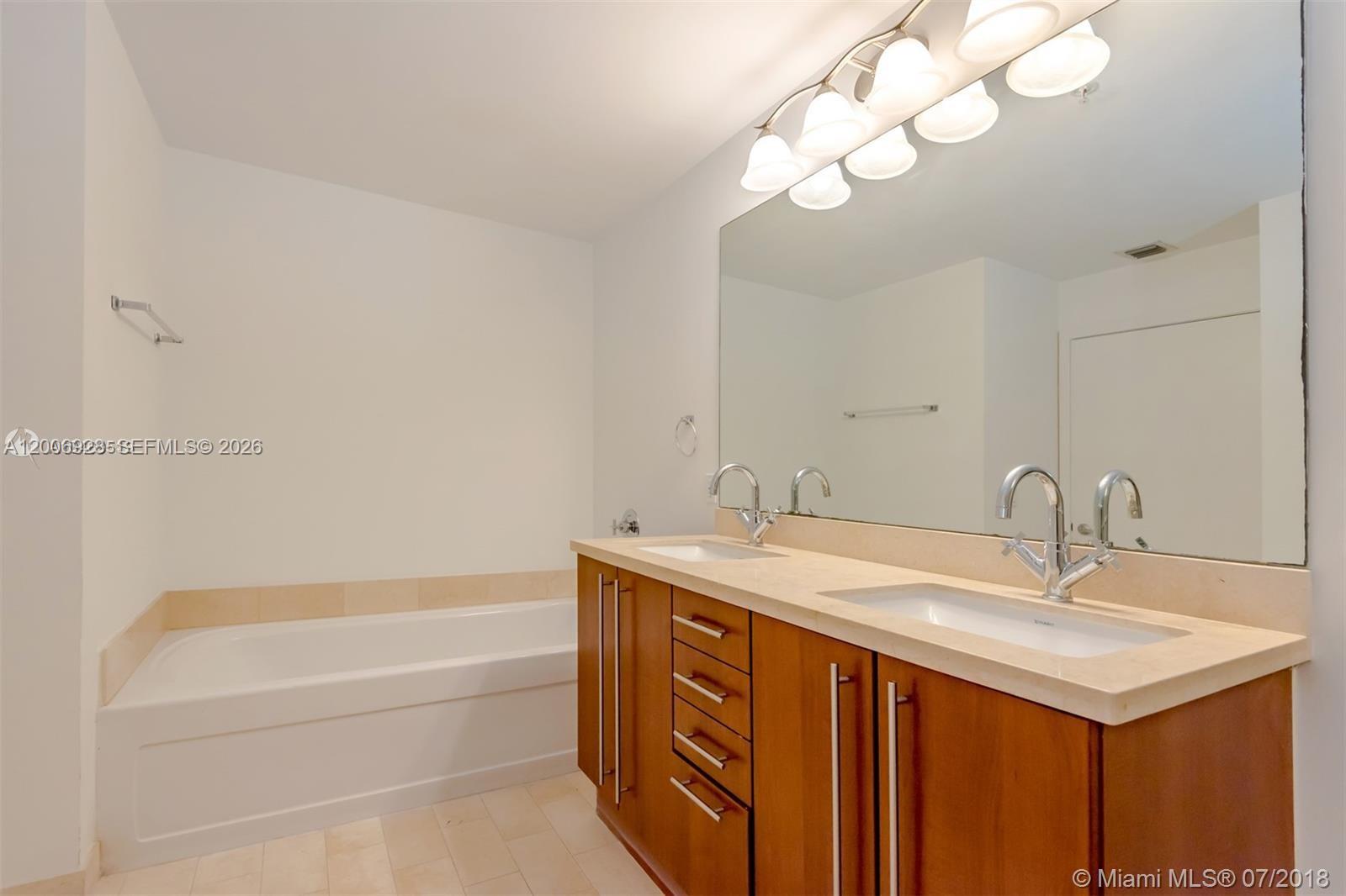 79 Southwest 12th Street, Unit 1903 Miami, FL 33130 - Photo 6 of 25 a bathroom with a sink a vanity and a mirror