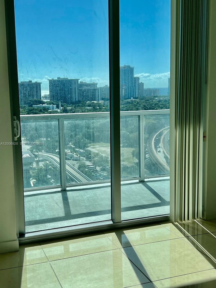 79 Southwest 12th Street, Unit 1903 Miami, FL 33130 - Photo 10 of 25 a view of a glass door and porch next to a yard
