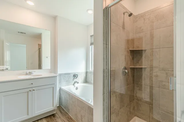 a bathroom with a tub sink shower and mirror