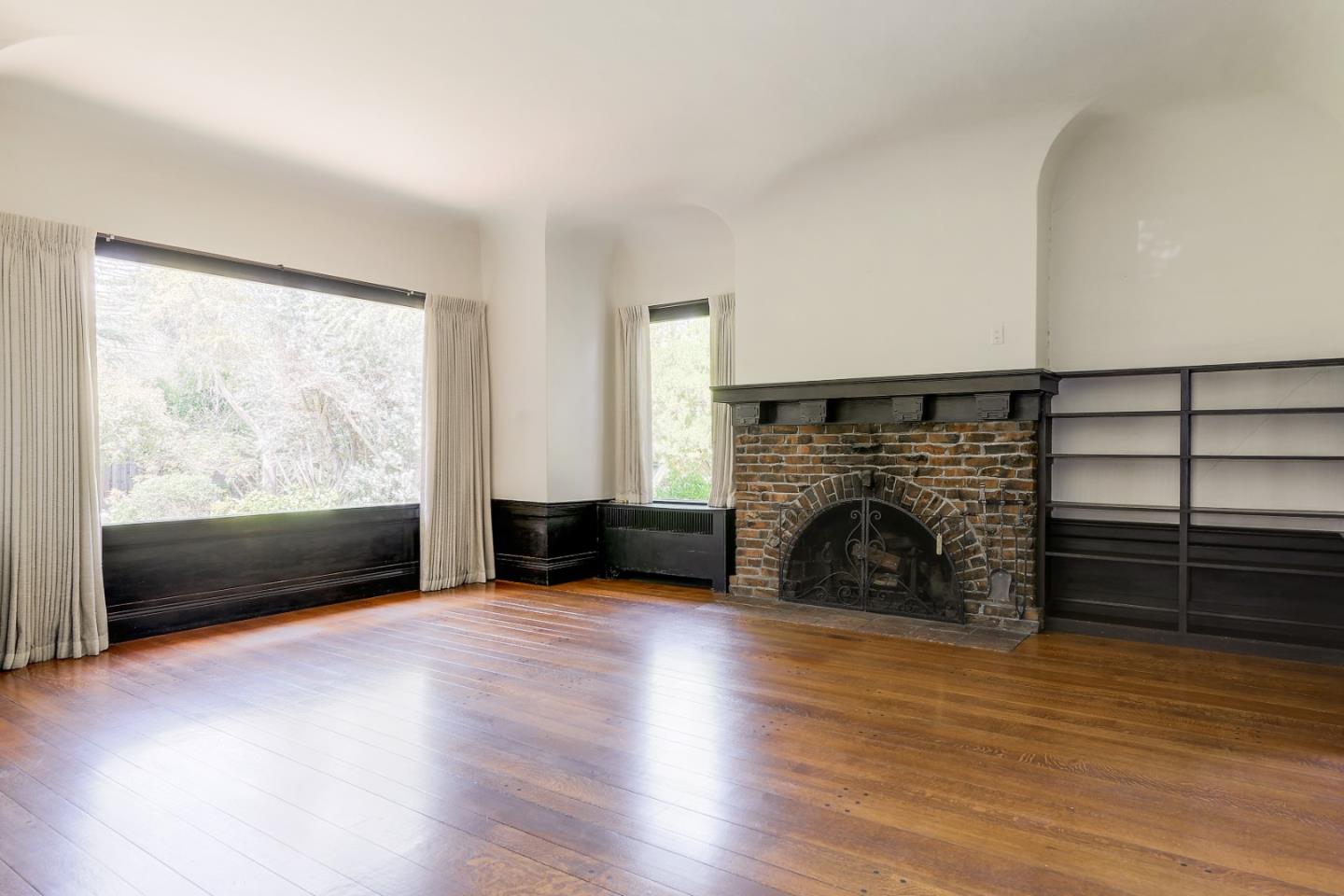 16 Maple Avenue Atherton, CA 94027 - Photo 6 of 25 an empty room with wooden floor fireplace and windows