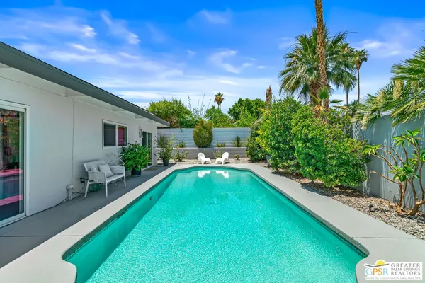 a swimming pool with outdoor seating and yard