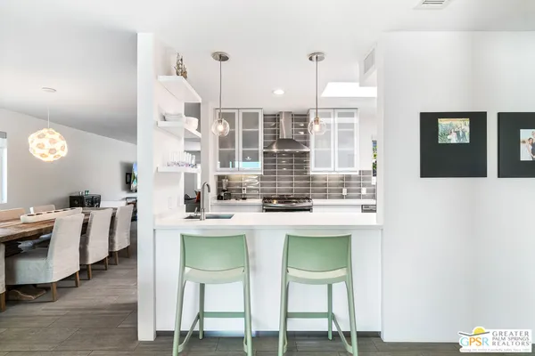 a kitchen with stainless steel appliances kitchen island granite countertop a table and chairs in it