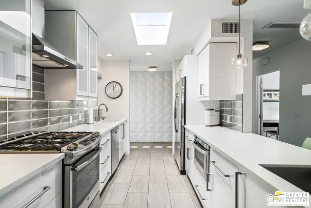 a kitchen with stainless steel appliances a stove a sink and a refrigerator