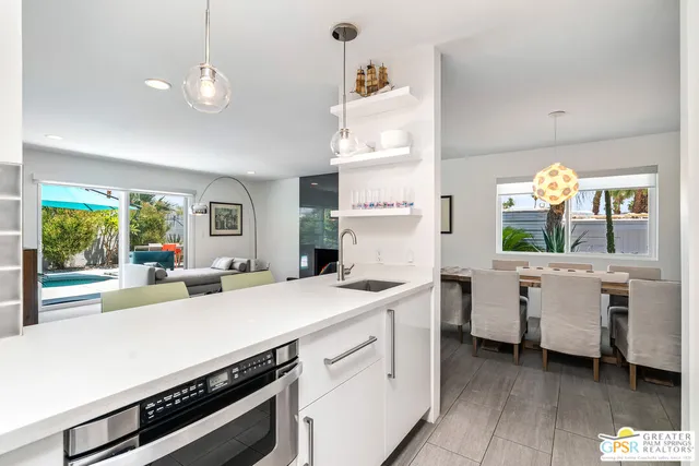 a kitchen that has a lot of cabinets in it and wooden floor