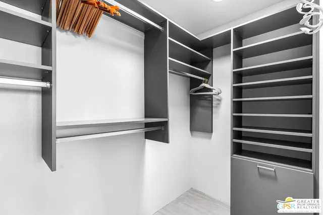 a view of walk in closet with empty racks