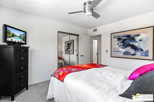 a bedroom with a bed and a painting on the wall