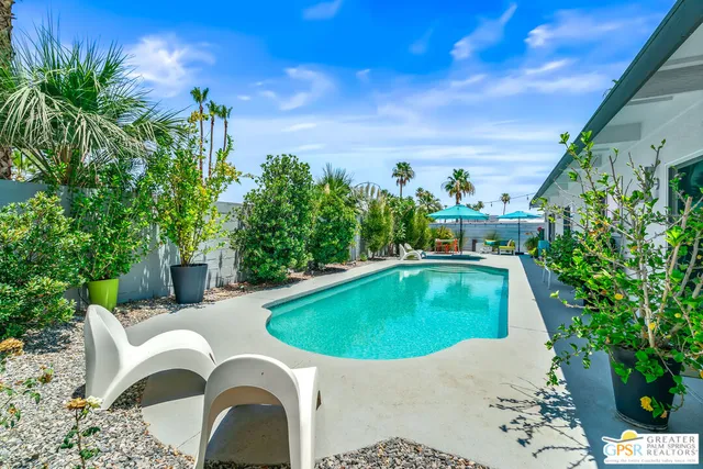 a swimming pool with outdoor seating yard and green space