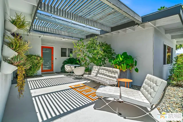 a view of a patio with couches table and chairs and potted plants