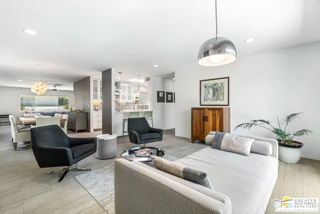 a living room with furniture kitchen and a chandelier