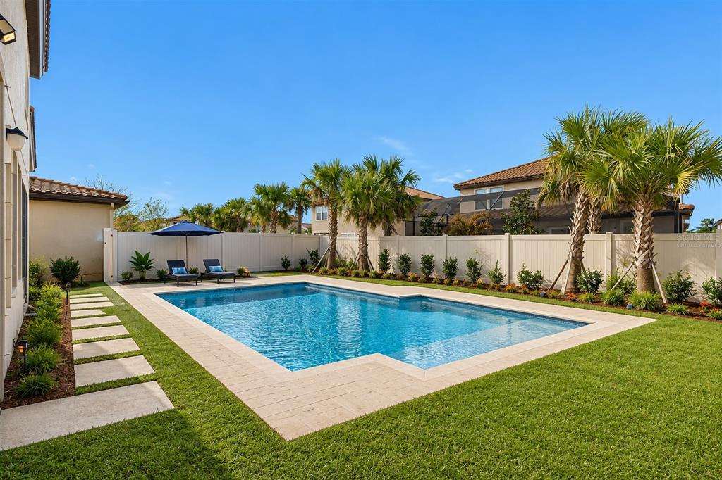 4300 Burdick Loop Odessa, FL 33556 - Photo 27 of 41 a view of swimming pool with seating area and trees in the background