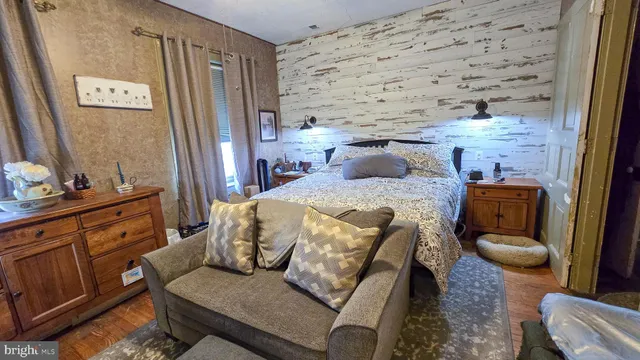 a bedroom with a bed a flat screen tv and chandelier