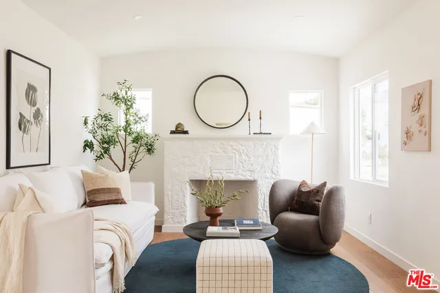 a living room with furniture a fireplace and a large mirror