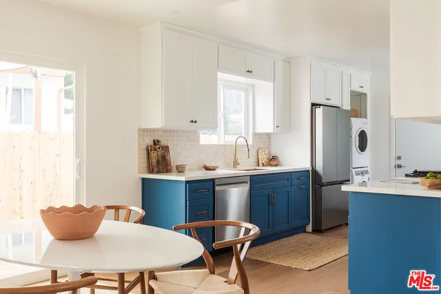 a kitchen with stainless steel appliances a dining table and chairs