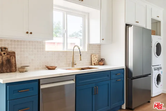 a kitchen with a sink a refrigerator and cabinets
