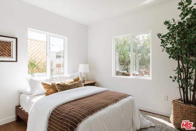 a bedroom with a large bed and a potted plant