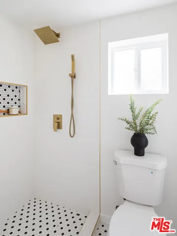 a white toilet sitting next to a window