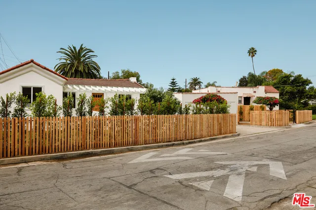 a view of a house with a yard and potted plants