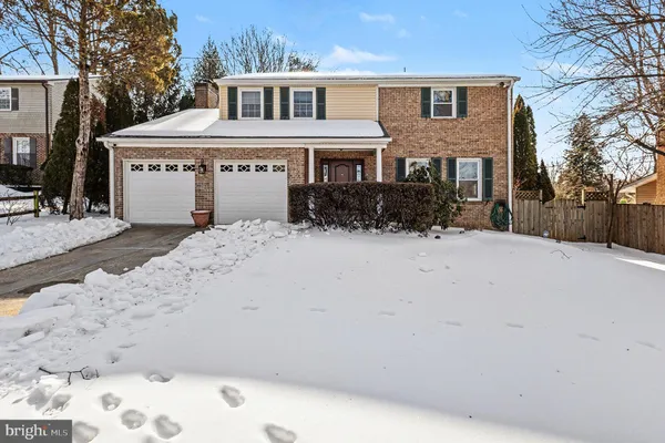 a front view of a building with a yard covered with snow