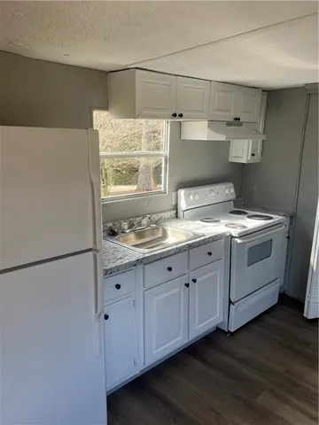 a kitchen with a sink cabinets and wooden floor