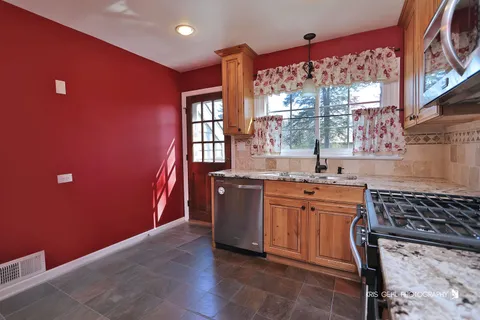 a kitchen with stainless steel appliances granite countertop a stove a sink and a microwave