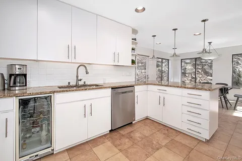 a kitchen with granite countertop white cabinets and white appliances