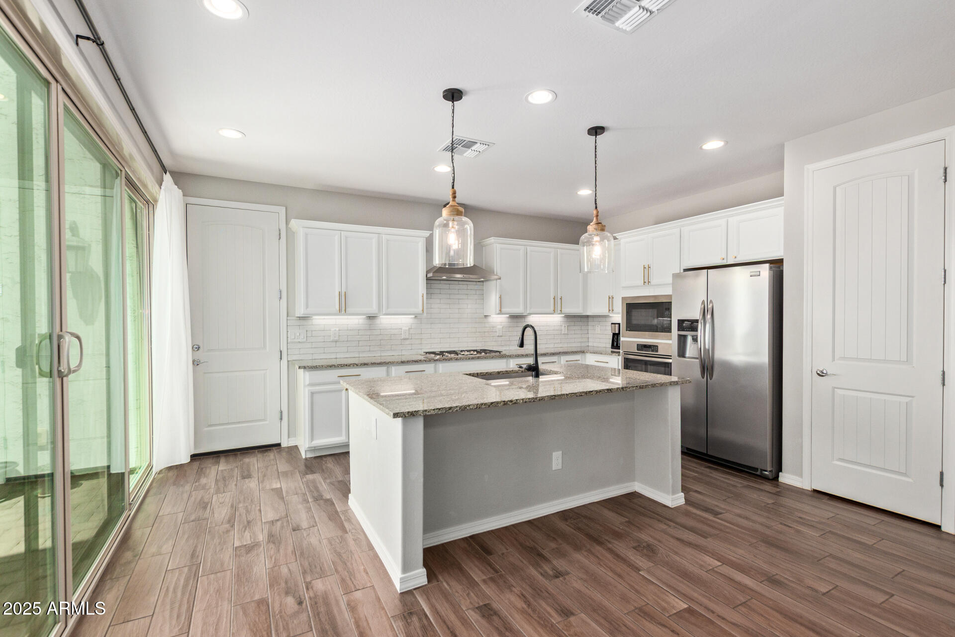 3934 East Turley Street Gilbert, AZ 85295 - Photo 7 of 37 a kitchen with stainless steel appliances granite countertop a sink a stove a refrigerator and island with wooden floor
