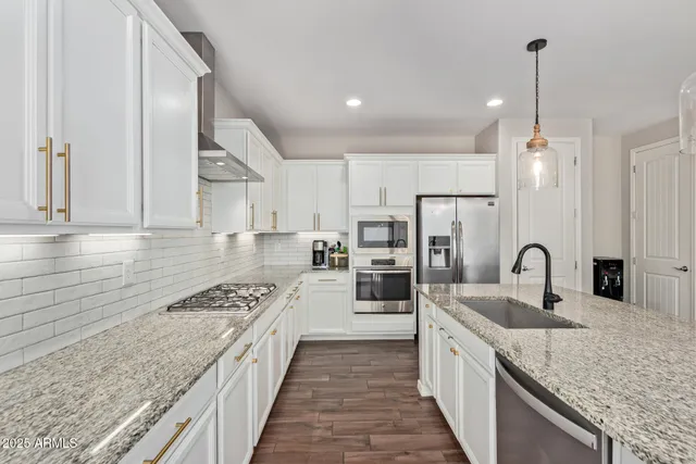 a kitchen with stainless steel appliances granite countertop a sink stove and refrigerator