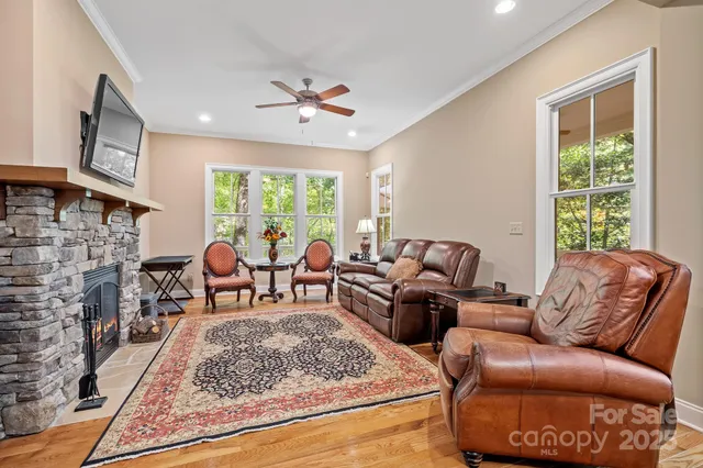 a living room with furniture fireplace and a large window